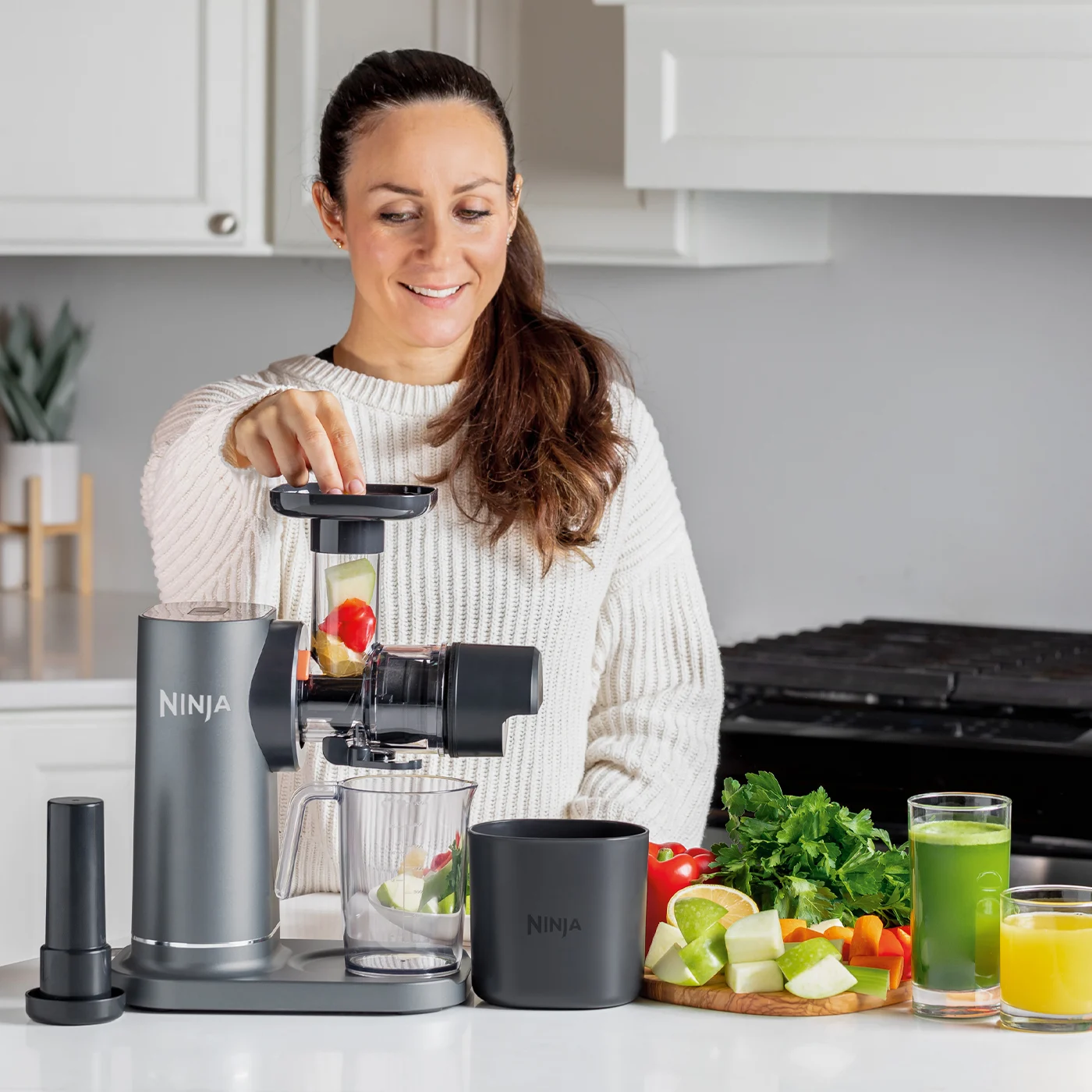 Ninja-JC151UK-InUse-LineUp-OnIsland-FillFunnel-ONinjaange-GNinjaeenJuice-Woman_ux8upp