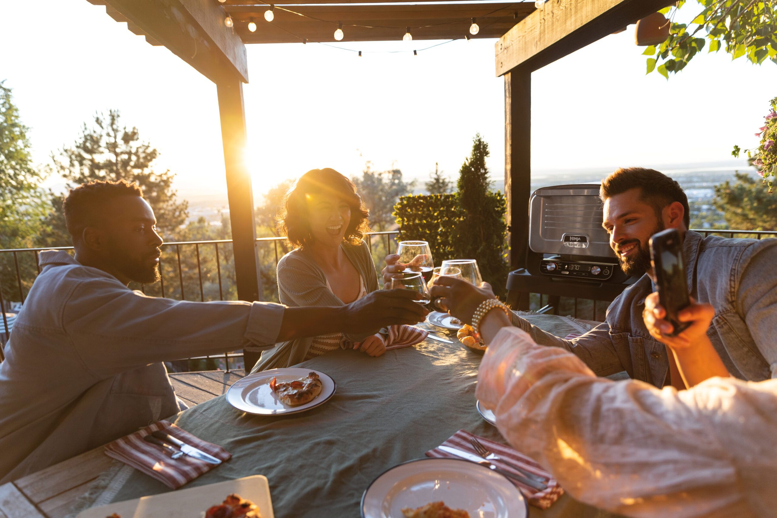 Ninja-OO101UK_InUse_Balcony_OnStand_TableSet_Group_Cheers_RT RGB
